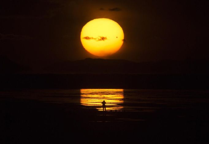 The planet Venus makes a transit as a person watches the sun set over the Great Salt Lake outside Salt Lake City, Utah, June 5, 2012. The planet Venus made a slow transit across the face of the sun on Tuesday, the last such passing that will be visible from Earth for 105 years. REUTERS/Jim Urquhart (UNITED STATES - Tags: SCIENCE TECHNOLOGY ENVIRONMENT) Published: Čer. 6, 2012, 3:58 dop.