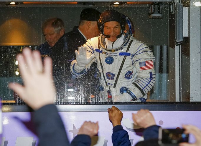 Astronaut Jeff Williams mává z autobusu, jenž posádku dopravil k místu odletu na kosmodromu Bajkonur.