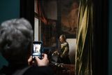 Návštěvnice výstavy si fotí Dívku u okna čtoucí dopis z roku 1657, kterou na výstavu zapůjčila Galerie starých mistrů v drážďanském Zwingeru.