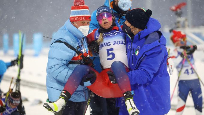 Členové norského týmu odnášejí Ingrid Tandrevoldovou po stíhacím závodu