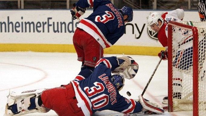 Gólman New Yorku Rangers Henrik Lundqvist (na zemi) likviduje spolu s Michalem Rozsívalem (3) šanci montrealského Tomáše Plekance (vlevo).