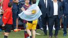 Atletico Madrid's Insua, with Argentine national flag draped over his shoulders, speaks to his compatriot Barcelona's Messi, as coach Martino stands nearby after Atletico