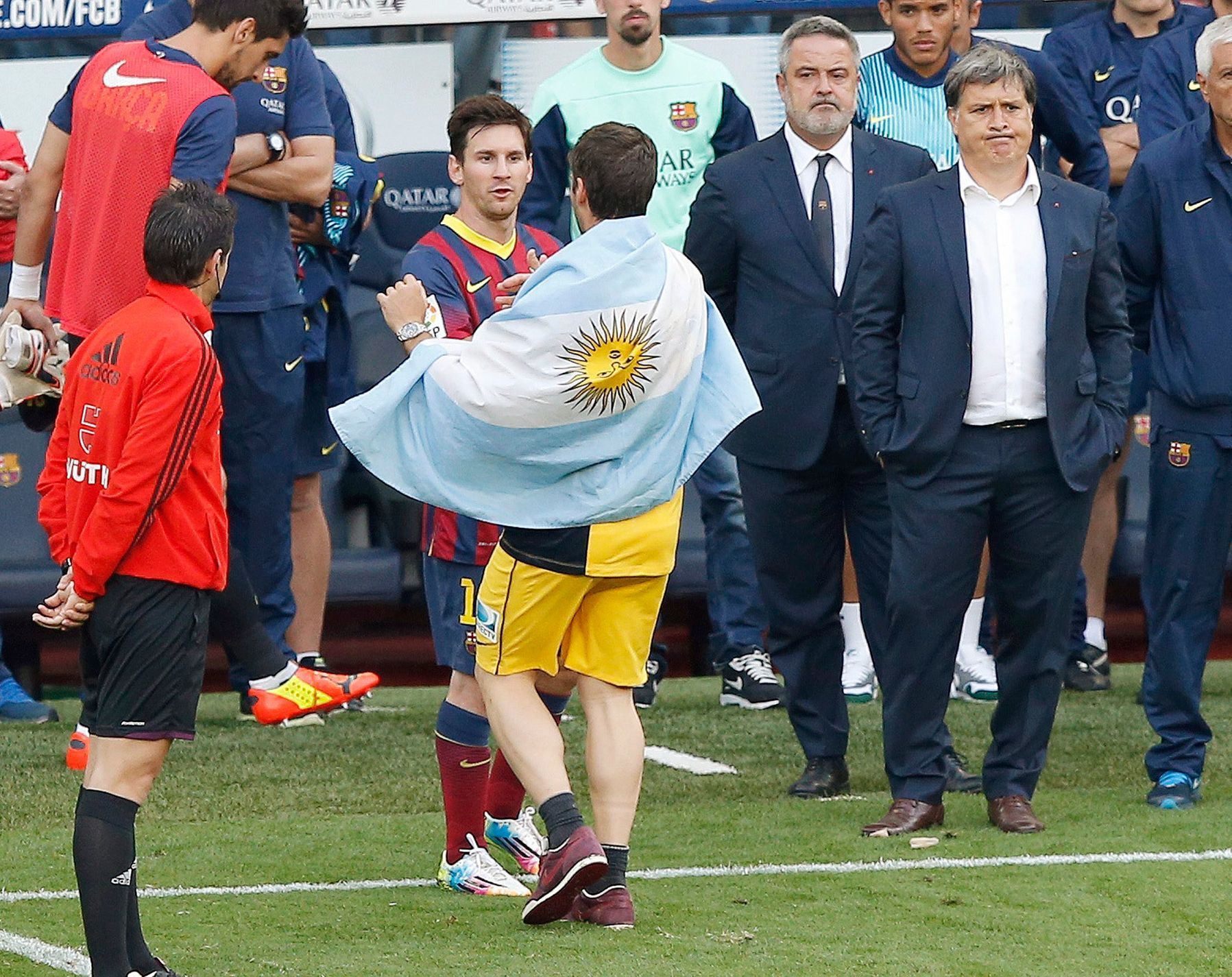 Atletico Madrid's Insua, with Argentine national flag draped over his shoulders, speaks to his compatriot Barcelona's Messi, as coach Martino stands nearby after Atletico Madrid won their Spanish firs