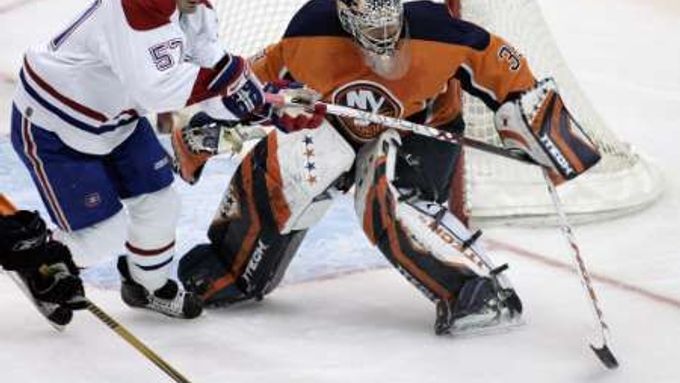 Brankář New Yorku Islanders goalie Rick DiPietro chtá střelu centra Montrealu Canadiens Gartha Murrayho.