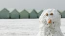 A snowman stands near beach huts in Brighton, southern England March 12, 2013. Southern England was hit with heavy snow overnight. REUTERS/Luke MacGregor (BRITAIN - Tags: ENVIRONMENT SOCIETY) Published: Bře. 12, 2013, 1:12 odp.