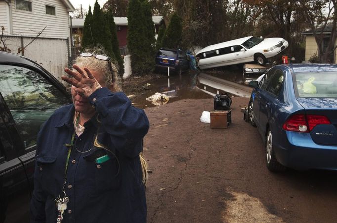 RNPS IMAGES OF THE YEAR 2012 - A woman weeps after learning that a neighbor presumed missing is okay while cleaning out her home in a neighborhood heavily damaged by Hurricane Sandy in the New Dorp Beach neighborhood of the Staten Island borough of New York, November 1, 2012. Deaths in the United States and Canada from Sandy, the massive storm that hit the U.S. East Coast this week, rose to at least 95 on Thursday after the number of victims reported by authorities in New York City jumped and deaths in New Jersey and elsewhere also rose. REUTERS/Lucas Jackson (UNITED STATES - Tags: ENVIRONMENT DISASTER TPX IMAGES OF THE DAY) Published: Pro. 5, 2012, 11:11 odp.