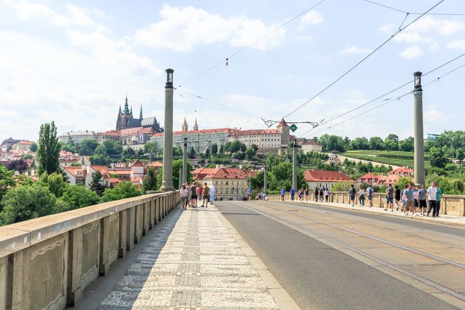 Lidé kráčející po Mánesově mostě v Praze v roce 2017.
