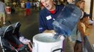 Dan Eper who works in the Atlanta Braves guest relations department fills a cooler with free water for fans attending the Atlanta Braves baseball game against the Washington Nationals at Turner Field in Atlanta, Georgia June 30, 2012. A record-breaking heatwave has covered most of the country with temperatures expected to be 105 degrees Fahrenheit (41 degrees Celsius) in Atlanta. REUTERS/Tami Chappell (UNITED STATES - Tags: ENVIRONMENT SPORT BASEBALL) Published: Čec. 1, 2012, 12:25 dop.