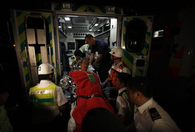 A survivor is taken onto shore by rescuers after a collision involving two vessels in Hong Kong October 2, 2012. A major rescue is underway in the waters near Yung Shue Wan on Hong Kong's Lamma island following a collision involving two vessels in the evening, government radio reported on Monday. Police say there were about 100 people onboard both vessels, with many of them in the water. The government says 101 people have been rescued so far with at least 25 hospitalised. REUTERS/Tyrone Siu (CHINA - Tags: DISASTER TRANSPORT) Published: Říj. 1, 2012, 7:26 odp.