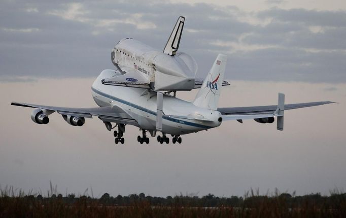 The space shuttle Discovery, attached to a modified NASA 747 aircraft, takes off in Cape Canaveral