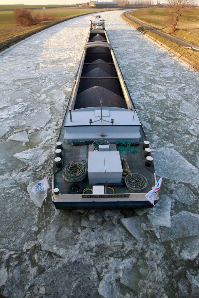 Tanker si razí cestu zamrzlým Canal du Nord u Graincourt les Havrincourt, Francie.