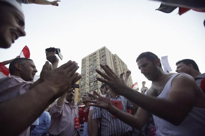 Protesters, who are against Egyptian President Mohamed Mursi, dance and react in front of the Republican Guard headquarters in Cairo July 3, 2013. Egypt's armed forces overthrew elected Islamist President Mohamed Mursi on Wednesday and announced a political transition with the support of a wide range of political, religious and youth leaders. A statement published in Mursi's name on his official Facebook page after head of Egypt's armed forces General Abdel Fattah al-Sisi's speech said the measures announced amounted to "a full military coup" and were "totally rejected". REUTERS/Amr Abdallah Dalsh (EGYPT - Tags: POLITICS CIVIL UNREST) Published: Čec. 3, 2013, 8:53 odp.