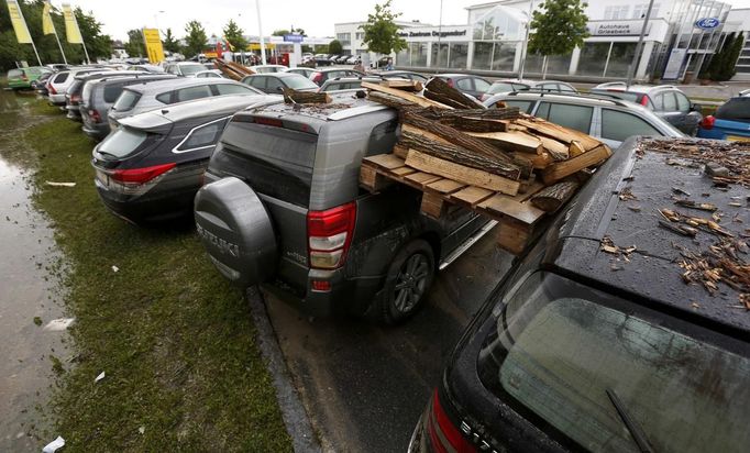 A wooden pallet and burning wood got stuck between two cars after the floods of the nearby Danube river subsided at a car dealership in Fischerdorf, a suburb of the eastern Bavarian city of Deggendorf June 10, 2013. Tens of thousands of people have been forced to leave their homes and there have been at least a dozen deaths as a result of floods that have hit Germany, Austria, Slovakia, Poland and the Czech Republic over the past week. REUTERS/Wolfgang Rattay (GERMANY - Tags: DISASTER TRANSPORT)