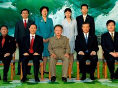Kim Čong-il na skupinové fotografii pořízené u příležitosti návštěvy šéfa zahraniční sekce čínské komunistické strany Wang Ťia-žueje (po Kimově pravici) v Pchjongjangu
