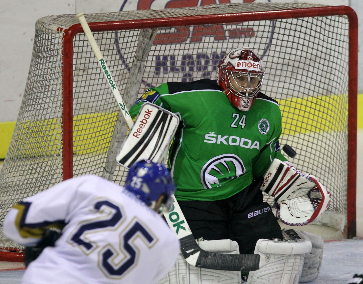Mladoboleslavský hokejový brankář Vlastimil Lakosil sleduje střelu kladenského Marka Hovorky v přípravném utkání před sezónou 2012/13.