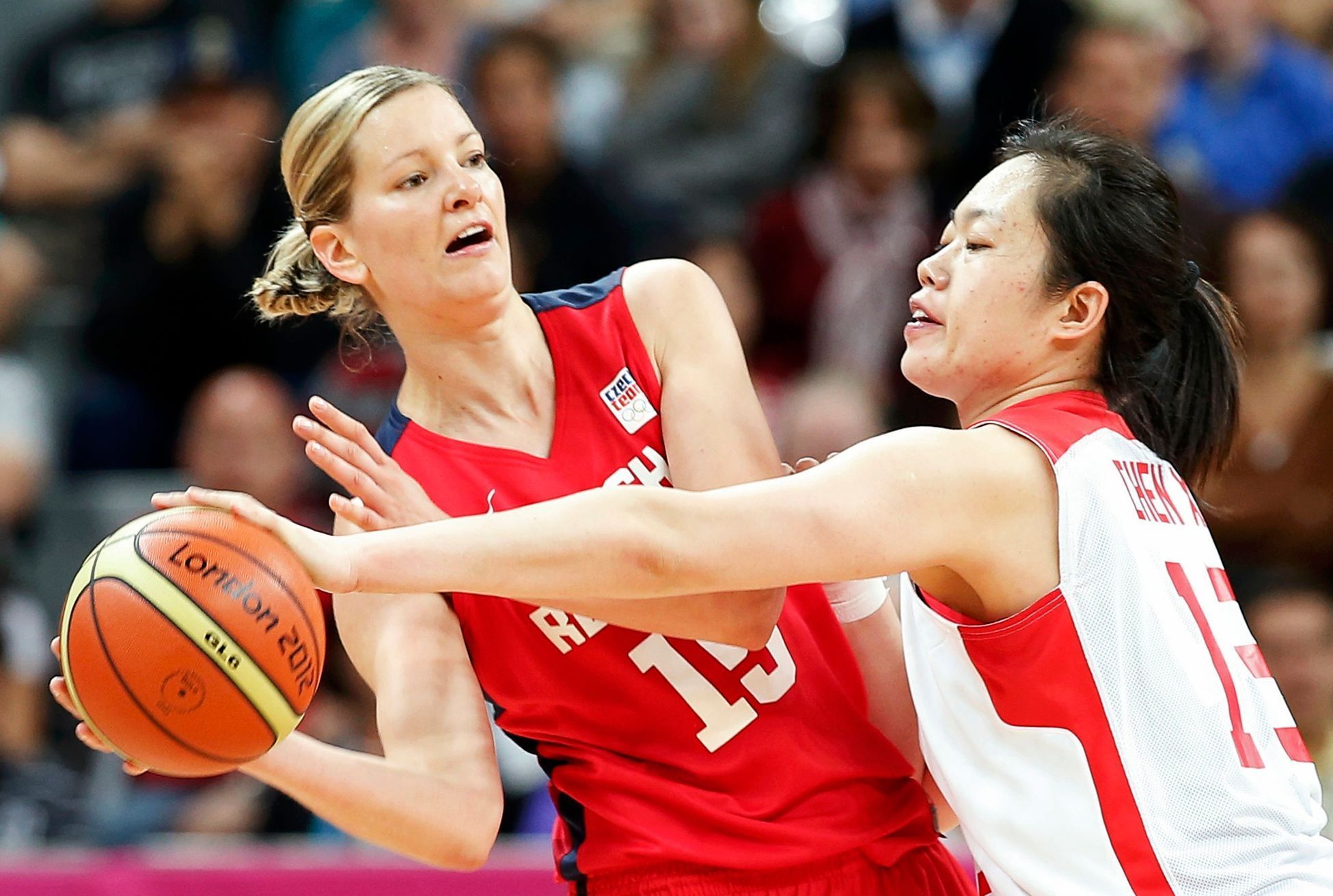 Česká basketbalistka Eva Vítečková (vlevo) se snaží prostřelit Číňanku Xiaoli Čengovou v turnaji OH 2012 v Londýně.