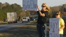 Sherry Johnson Parker and her daughter Olivia Parker hold signs along Highway 231 asking drivers to pray for Ethan, a 5-year-old boy taken hostage five days ago, after a bus driver was shot and killed near Midland City, Alabama February 3, 2013. Mourners in the small town of Midland City, Alabama, gathered on Sunday to bury a school bus driver slain during the abduction of a child taken captive and held for a sixth day by a gunman in an underground bunker. REUTERS/Phil Sears (UNITED STATES - Tags: CRIME LAW OBITUARY) Published: Úno. 4, 2013, 1:20 dop.