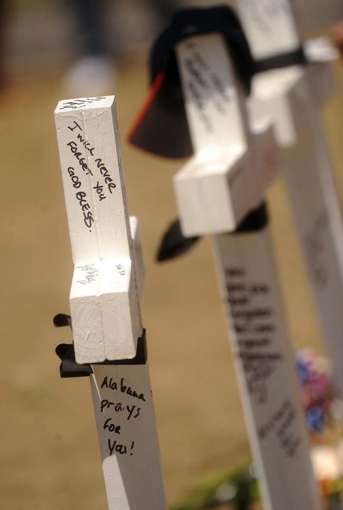 Messages are seen on crosses at a memorial for victims in Aurora, Colorado July 22, 2012. The makeshift memorial was erected behind the theater where a gunman opened fire on moviegoers during a midnight premiere showing of "The Dark Knight Rises" on July 20, 2012. Residents of a Denver suburb mourned their dead on Sunday from a shooting rampage by a "demonic" gunman who killed 12 people and wounded 58 after opening fire at a cinema showing the new Batman movie. President Barack Obama headed to Aurora, Colorado, on Sunday to meet families grieving their losses Friday's mass shooting that has stunned the nation and rekindled debate about guns and violence in America. REUTERS/Evan Semon (UNITED STATES - Tags: CRIME LAW SOCIETY) Published: Čec. 22, 2012, 11:27 odp.