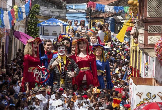 Revellers carry giant figures during the Carnival parade in Olinda, in the northeastern state of Pernambuco, February 12, 2013. REUTERS/Alexandre Severo (BRAZIL - Tags: SOCIETY) Published: Úno. 12, 2013, 8:53 odp.