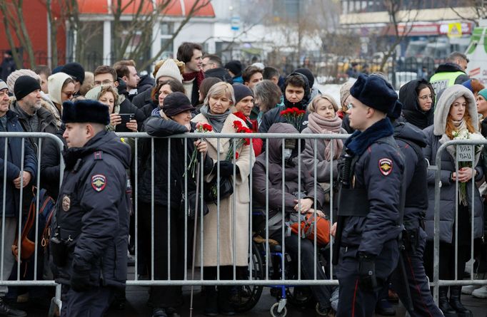 Lidé čekali už tři hodiny před začátkem s květinami před hřbitovem. Policisté před ně postavili zátarasy.