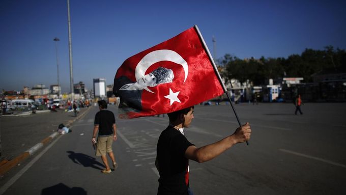 Demonstrant s tureckou vlajkou na istanbulskému náměstí Taksim.