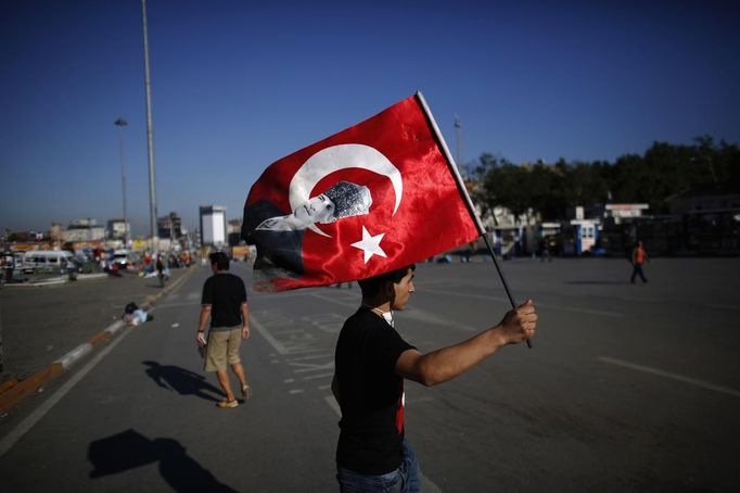 Demonstrant s tureckou vlajkou na istanbulskému náměstí Taksim.