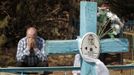 Belarussian man sits at his relative's grave on the eve of Radunitsa in the abandoned village of Tulgovichi