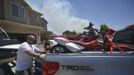 The Coulter family gets ready to leave their home after receiving an evacuation notice near Saratoga Springs, Utah, June 22, 2012. More than 1,000 homes were evacuated from two small Utah communities on Friday as high winds whipped up a brush fire triggered by target shooters and pushed the flames toward houses and a nearby explosives factory. REUTERS/Jeff McGrath (UNITED STATES - Tags: ENVIRONMENT DISASTER) Published: Čer. 22, 2012, 11:43 odp.