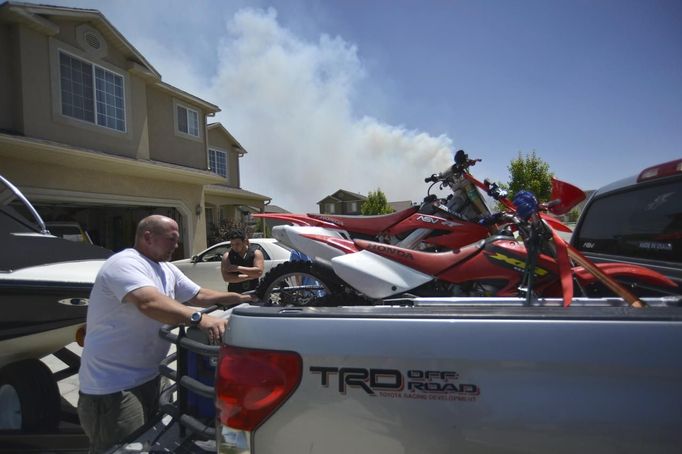 The Coulter family gets ready to leave their home after receiving an evacuation notice near Saratoga Springs, Utah, June 22, 2012. More than 1,000 homes were evacuated from two small Utah communities on Friday as high winds whipped up a brush fire triggered by target shooters and pushed the flames toward houses and a nearby explosives factory. REUTERS/Jeff McGrath (UNITED STATES - Tags: ENVIRONMENT DISASTER) Published: Čer. 22, 2012, 11:43 odp.