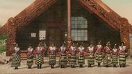 Maorští tanečníci před vyřezávaným domem ve vesnici Ohinemutu u jezera Rotorua. V době, kdy vznikla tato fotografie, tedy mezi lety 1890 až 1910, bylo Ohinemutu hlavním centrem celého okolního regionu.