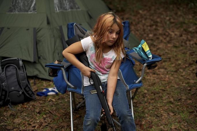 Brianna, 9, of the North Florida Survival Group waits with her rifle as she prepares to join adults and other children in performing enemy contact drills during a field training exercise in Old Town, Florida, December 8, 2012. The group trains children and adults alike to handle weapons and survive in the wild. The group passionately supports the right of U.S. citizens to bear arms and its website states that it aims to teach "patriots to survive in order to protect and defend our Constitution against all enemy threats". Picture taken December 8, 2013. REUTERS/Brian Blanco (UNITED STATES - Tags: SOCIETY POLITICS) ATTENTION EDITORS: PICTURE 20 OF 20 FOR PACKAGE 'TRAINING CHILD SURVIVALISTS' SEARCH 'FLORIDA SURVIVAL' FOR ALL IMAGES