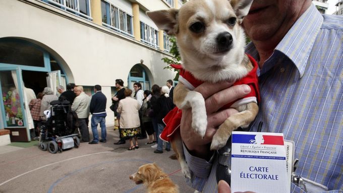 Muž stojí se psem ve frontě před volební místností v Nice.