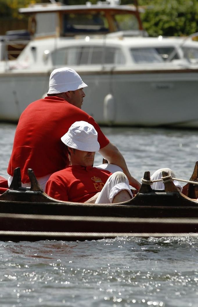 A Queen's Swan Upper sits in the sun during the annual Swan Upping ceremony on the River Thames between Shepperton and Windsor in southern England July 15, 2013. Young c