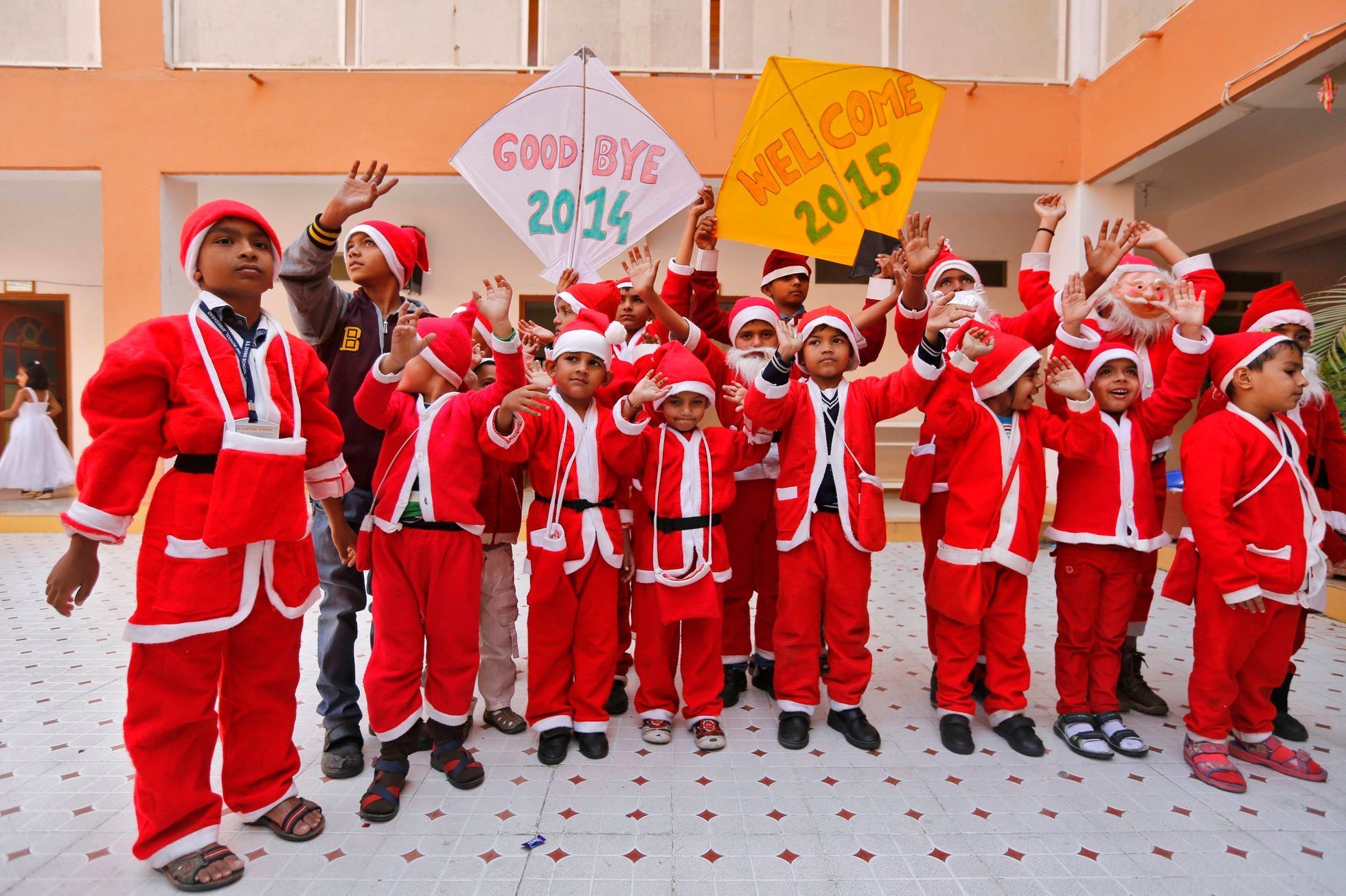 School students dressed in Santa Claus costumes pose during their New Year's Day celebrations at a school in Ahmedabad