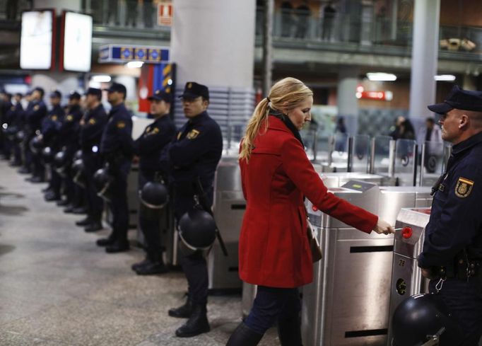 A commuter passes a line of police as she enters a gantry at Atocha rail station during a 24-hour nationwide general strike in Madrid, November 14, 2012. Spanish and Portuguese workers staged the first coordinated strike across the Iberian peninsula on Wednesday, shutting down transport, grounding flights and closing schools to protest austerity measures and tax hikes. REUTERS/Paul Hanna (SPAIN - Tags: POLITICS CIVIL UNREST BUSINESS EMPLOYMENT TRANSPORT) Published: Lis. 14, 2012, 9:17 dop.