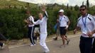 Alexander Loukos, British boxer of Greek descent, waves as he runs with the Olympic flame during the Olympic torch relay at the site of ancient Olympia in Greece May 10, 2012. REUTERS/John Kolesidis (GREECE - Tags: SPORT OLYMPICS) Published: Kvě. 10, 2012, 9:59 dop.