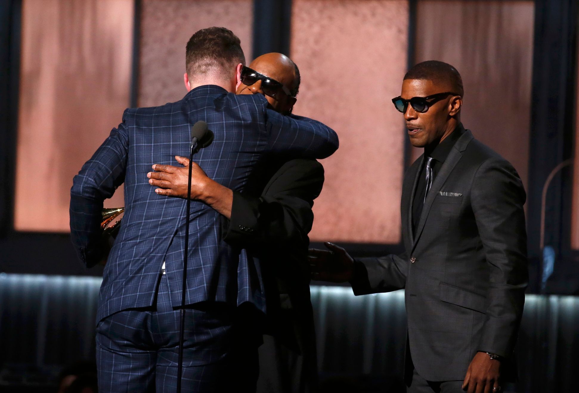 Smith accepts the award for record of the year from presenters Wonder and Foxx at the 57th annual Grammy Awards in Los Angeles