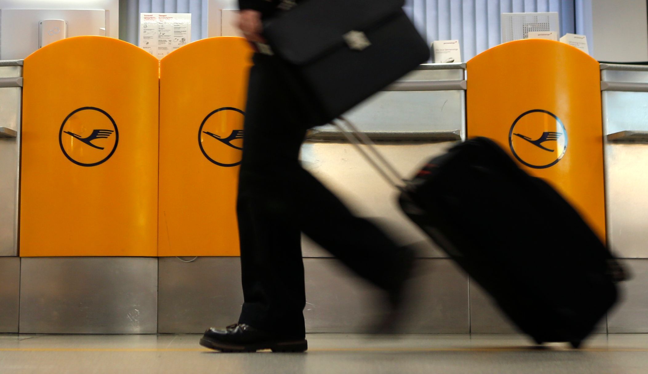 A passenger walks past a ticket counter of German air carrier Lufthansa at Berlin Tegel airport