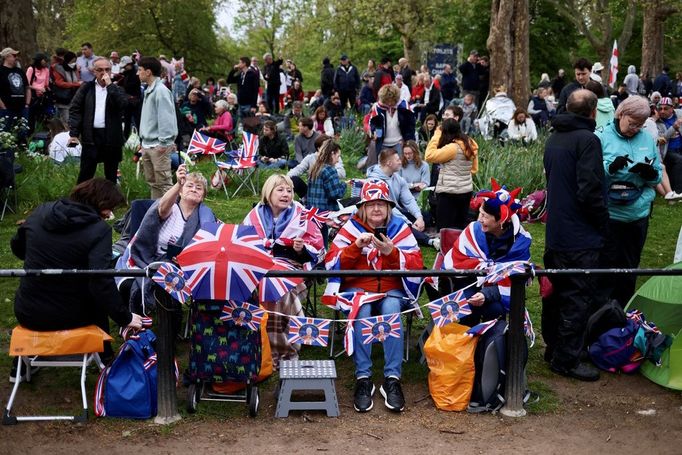 Lidé čekají podél londýnské třídy The Mall, kudy pojedou před polednem král Karel III. s královnou chotí Camillou z Buckinghamského paláce do Westminsterského opatství.