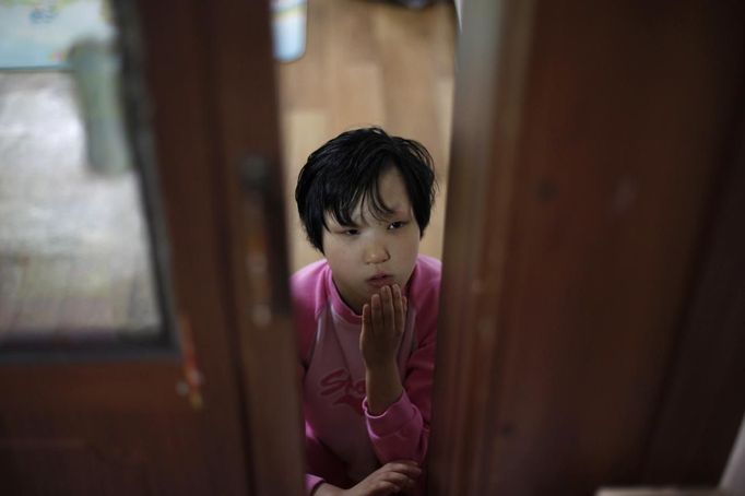 Choi Seol, 19, is seen at the Joosarang church in Seoul September 20, 2012. Choi, a disabled person, was abandoned at the church and has been raised there since. Pastor Lee Jong-rak, who runs the "baby box" at the church where mothers can leave unwanted infants, has seen a sharp increase in the number of newborns being left there because, he says, of a new law aimed protecting the rights of children. South Korea is trying to shed a reputation of being a source of babies for adoption by people abroad. It is encouraging domestic adoption and tightening up the process of a child's transfer from birth mother to adoptive parents. Picture taken September 20, 2012. REUTERS/Kim Hong-Ji (SOUTH KOREA - Tags: SOCIETY RELIGION) Published: Říj. 7, 2012, 6:54 dop.