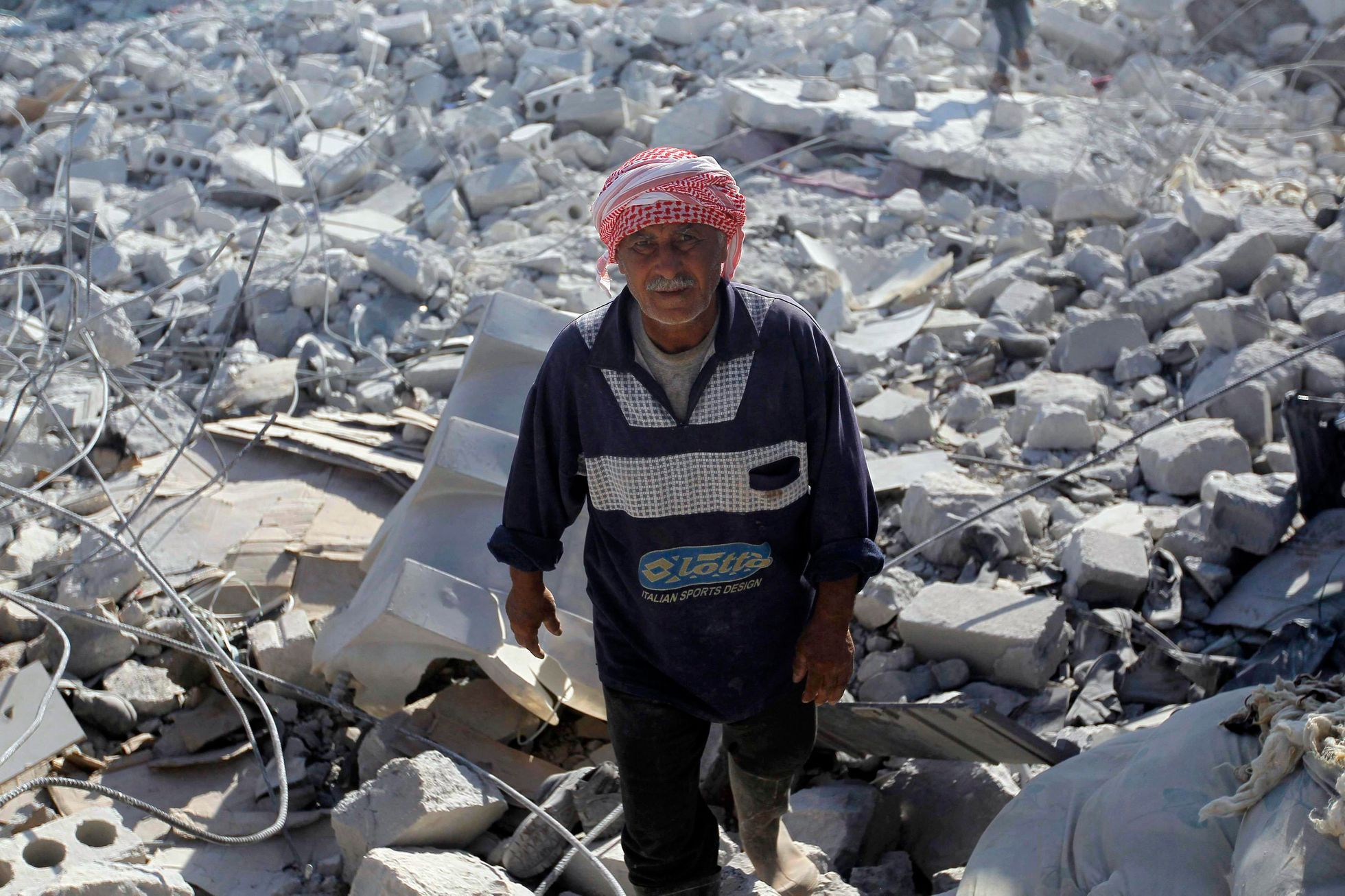 A man inspects a damaged site in what activists say was a U.S. strike, in Kfredrian