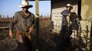 Israeli cowboys, Alon (R) and Amit (L), unload their horses after working with cattle in the early morning on a ranch just outside Moshav Yonatan, a collective farming community, about 2 km (1 mile) south of the ceasefire line between Israel and Syria in the Golan Heights May 21, 2013. Cowboys, who have been running the ranch on the Golan's volcanic rocky plateau for some 35 years, also host the Israeli military, who use half of the cattle farm, 20,000 dunams (5,000 acres), as a live-fire training zone. Israel captured the Golan Heights from Syria in the 1967 Middle East war and annexed the territory in 1981, a move not recognized internationally. Picture taken May 21, 2013. REUTERS/Nir Elias (ENVIRONMENT ANIMALS SOCIETY) ATTENTION EDITORS: PICTURE 21 OF 27 FOR PACKAGE 'COWBOYS OF THE GOLAN HEIGHTS' SEARCH 'COWBOY GOLAN' FOR ALL IMAGES Published: Kvě. 29, 2013, 10:08 dop.