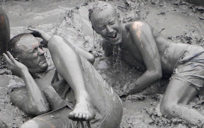 Tourists play in mud during the opening day of the Boryeong Mud Festival at Daecheon beach in Boryeong, about 190 km (118 miles) southwest of Seoul, July 14, 2012. About 2 to 3 million domestic and international tourists visit the beach during the annual festival, according to the festival organisation. REUTERS/Lee Jae-Won (SOUTH KOREA - Tags: SOCIETY TRAVEL) Published: Čec. 14, 2012, 1:34 odp.