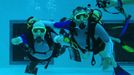 French athlete Philippe Croizon (L), whose arms and legs were amputated after an electric shock accident in March 1994, swims next to an unidentified diver in a 33 metre (36 yard) deep pool, the world's deepest pool built to train professional divers, at Nemo33 diving centre in Brussels January 10, 2013. Croizon, who swam with adapted prostheses that had fins attached, broke a world record and became the first disabled person to dive to 33 metres, according to the organisers. REUTERS/Yves Herman (BELGIUM - Tags: SOCIETY SPORT DIVING) Published: Led. 10, 2013, 4:39 odp.