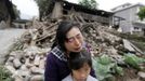 Song Zhengqiong, holding her daughter, cries in front of her damaged house after a strong 6.6 magnitude earthquake at Longmen village, Lushan county in Ya'an, Sichuan province April 21, 2013. Rescuers poured into a remote corner of southwestern China on Sunday as the death toll from the country's worst earthquake in three years climbed to 164 with more than 6,700 injured, state media said. REUTERS/Jason Lee (CHINA - Tags: DISASTER ENVIRONMENT TPX IMAGES OF THE DAY) Published: Dub. 21, 2013, 4:18 dop.