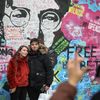 Lennonova zeď po třech měsících od malování - turisté, graffiti