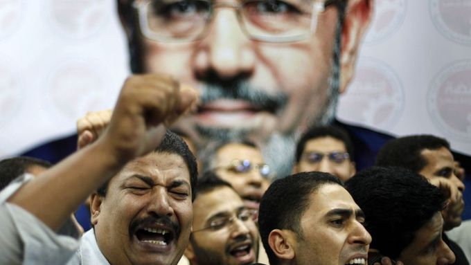Členové volebního štábu Muhammada Mursího se radují pod jeho velkým billboardem.