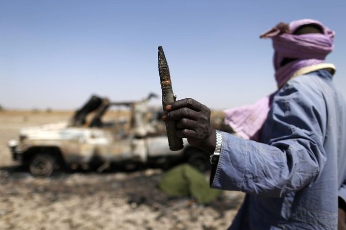 A Tuareg man holds a bullet near a destroyed vehicle belonging to Islamist rebels on the road between Diabaly and Timbuktu in Mali January 30, 2013. REUTERS/Benoit Tessier (MALI - Tags: POLITICS CONFLICT SOCIETY) Published: Led. 30, 2013, 9:28 odp.