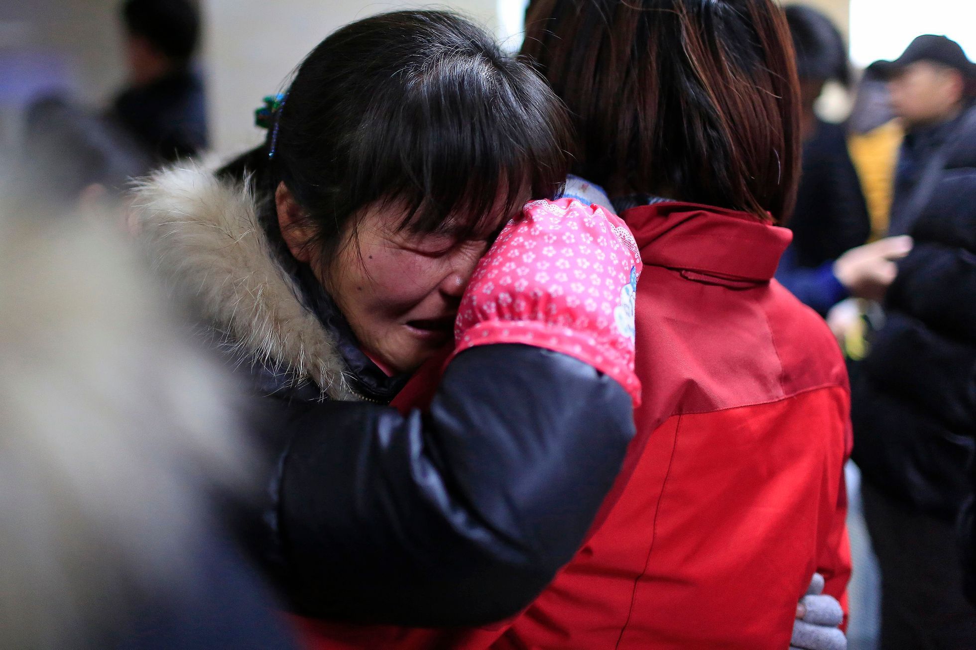 People cry at a hospital after a stampede occurred during a New Year's celebration on the Bund, central Shanghai
