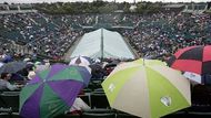 Diváci na centrálním kurtu Wimbledonu se musí schovávat pod deštníky, i v sobotu narušil program déšť.